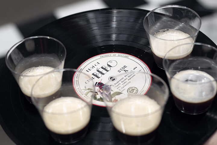 A detail shot of 5 glass with liquid arranged on a tray made from a vinyl record